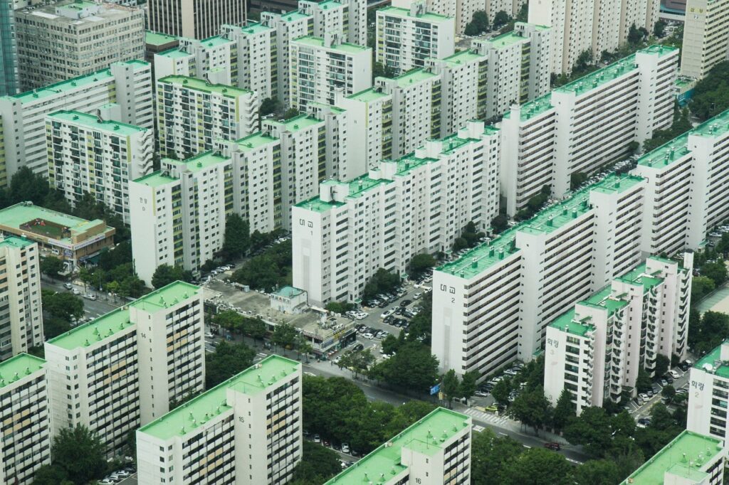 Alt Text: An aerial view of a dense high-rise apartment complex in Seoul, representing the competitive Korean housing market.