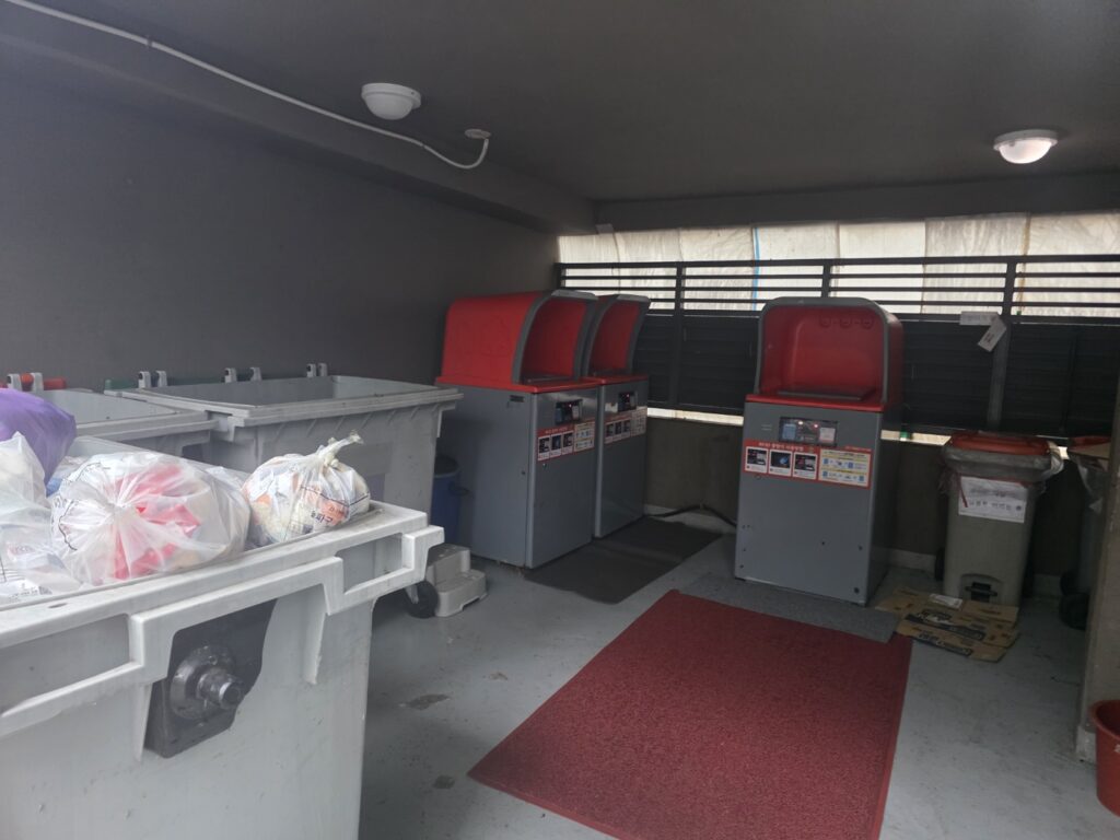 apartment-food-waste-collection-point-seoul A designated food waste collection area in a typical Korean apartment complex, featuring organized disposal bins and signage for residents.