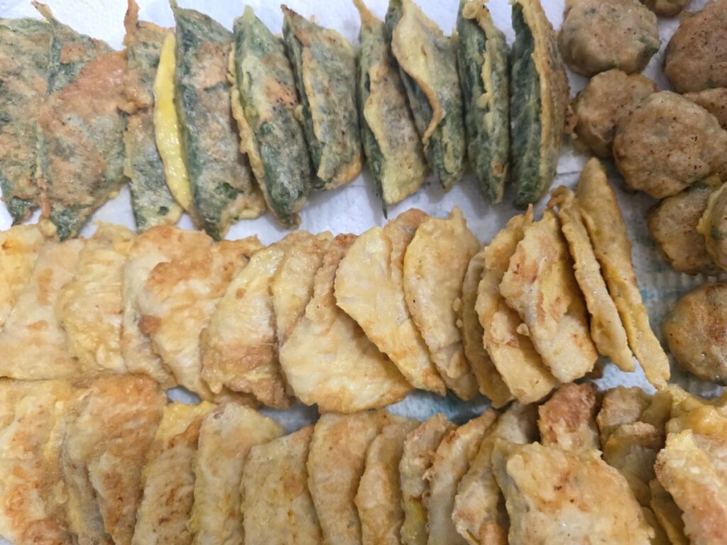 assorted-korean-jeon-holiday-table Assorted Korean jeon varieties — zucchini, fish, kimchi, and perilla leaf pancakes — beautifully arranged on a holiday table for family gathering.