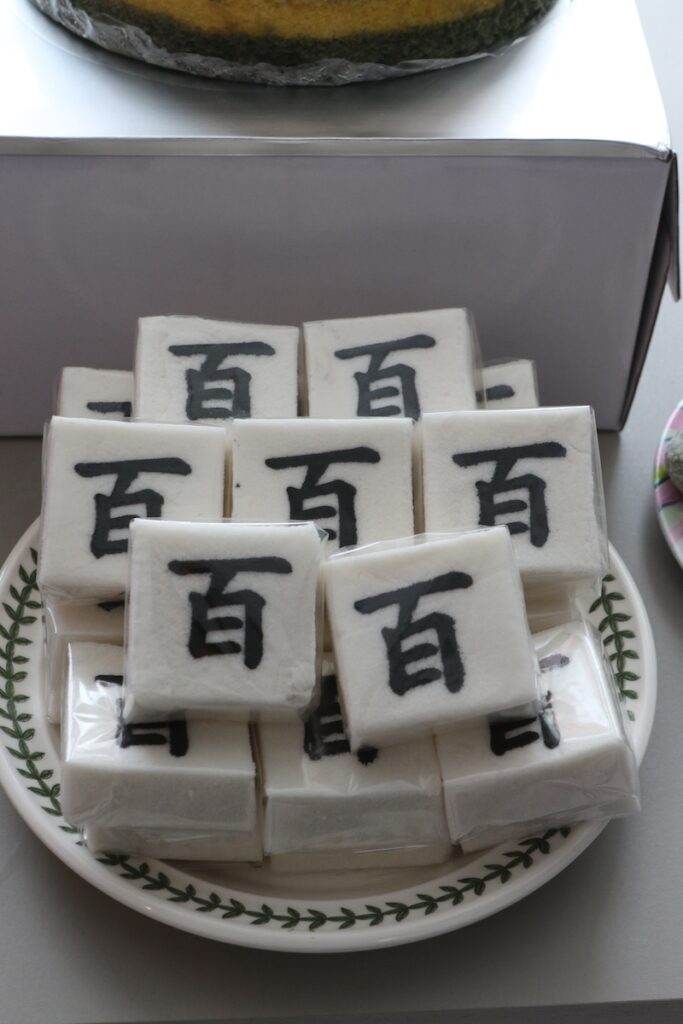 baekseolgi-rice-cakes-korean-first-birthday A stack of Baekseolgi rice cakes with the Chinese character 'Baek' (meaning 100) on them, symbolizing a long and healthy life during a Doljanchi ceremony.