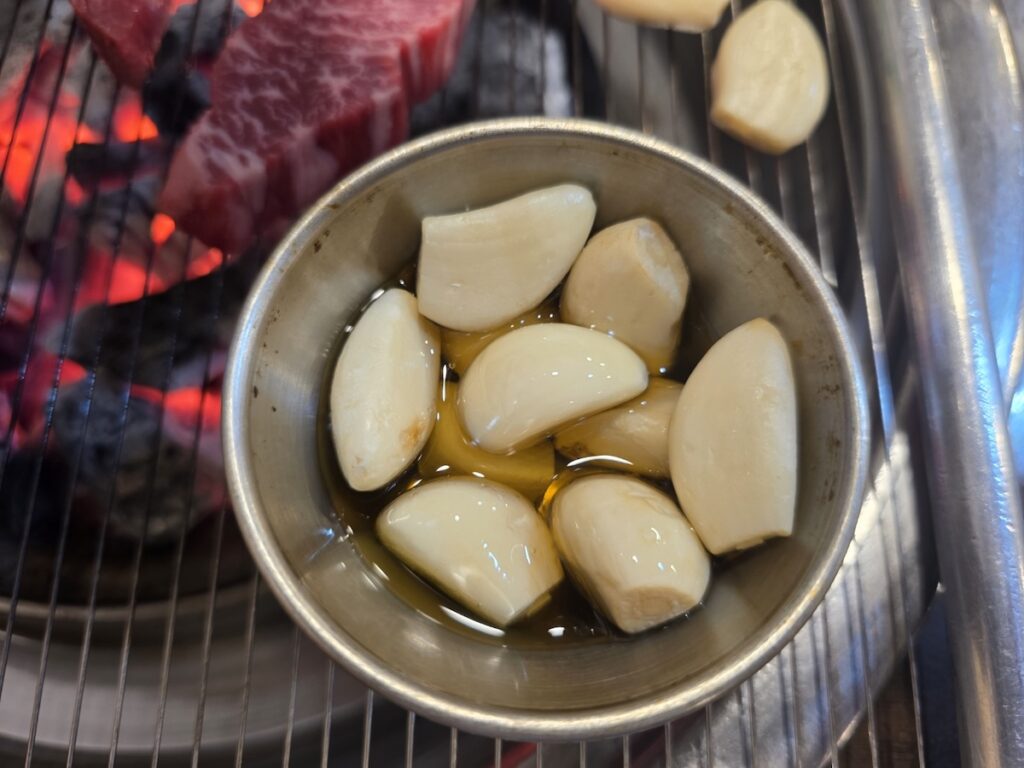 best-beef-bbq-in-seoul-authentic-experience Authentic Korean beef BBQ experience with garlic and side dishes at the best beef BBQ in Seoul.