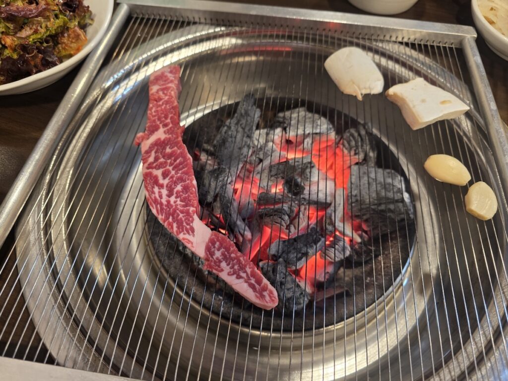 best-beef-bbq-in-seoul-charcoal-grill uicy beef grilling over traditional charcoal fire at the best beef BBQ in Seoul.