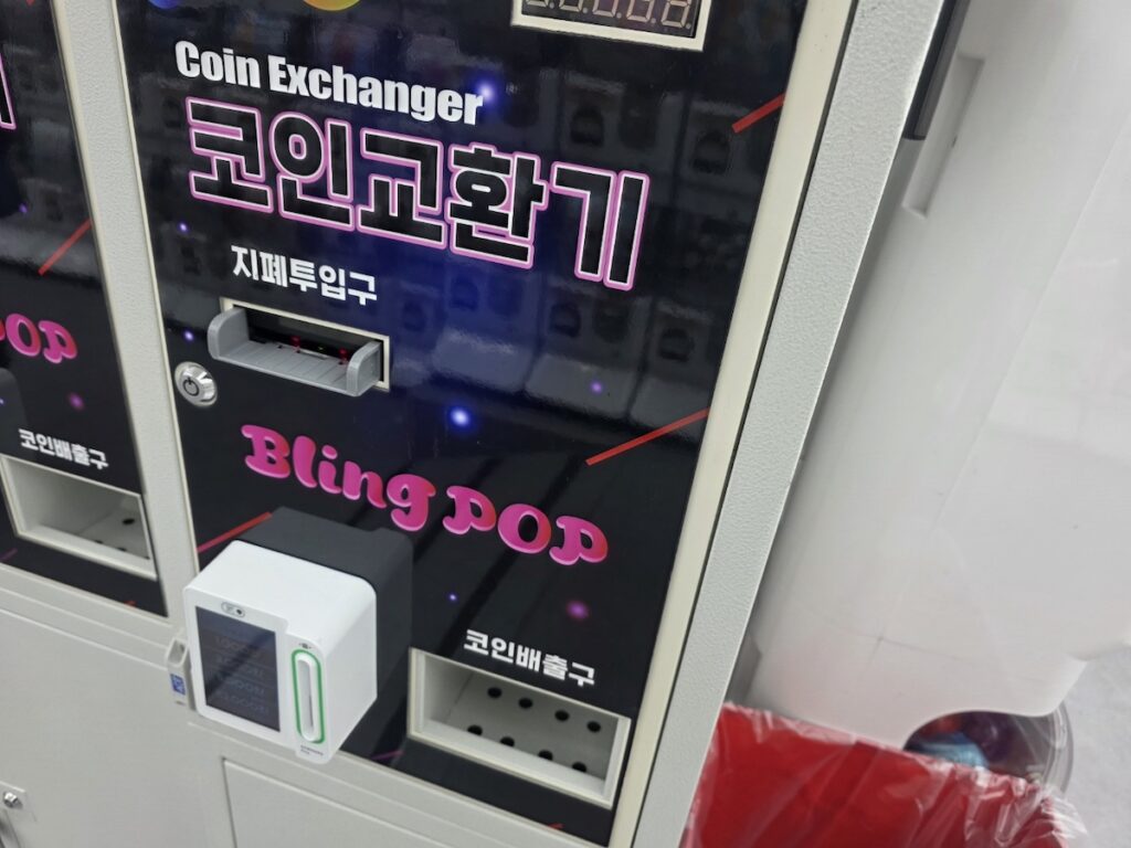 bill-to-coin-exchanger-korean-arcade A bill-to-coin exchange machine inside a Korean arcade, labeled in English and Korean.