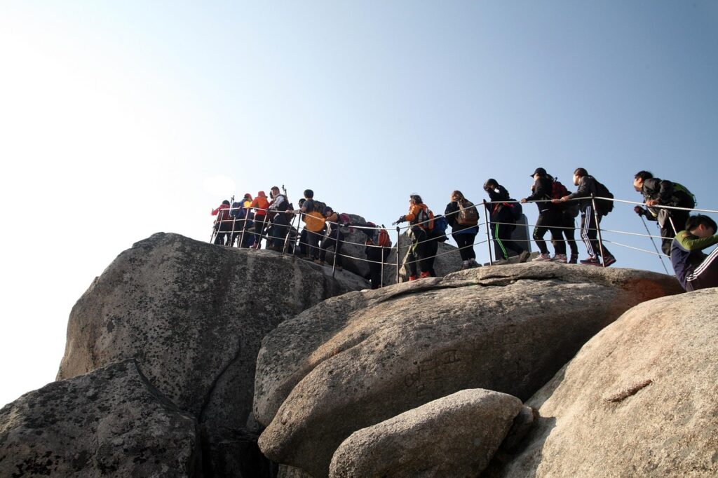 A panoramic view of Bukhansan Mountain in Seoul, South Korea, showing granite peaks, forest trails, and clear blue skies — a popular hiking spot easily accessible by public transport.
