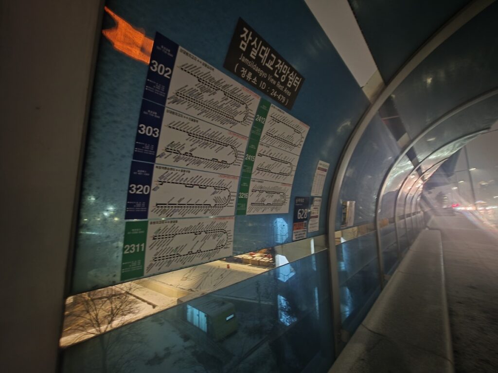 A bus route information board at a mid-bridge bus stop on Jamsil Bridge, Seoul smart transit system.