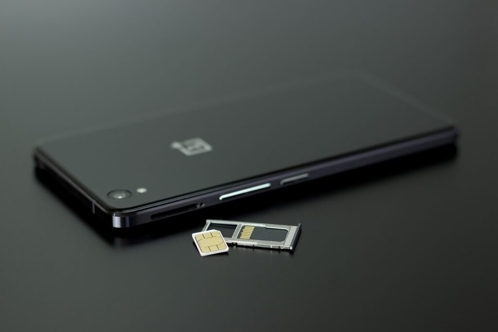 "A close-up shot of hands changing a SIM card in a smartphone, symbolizing mobile setup and connectivity for foreigners in Korea 2025."
