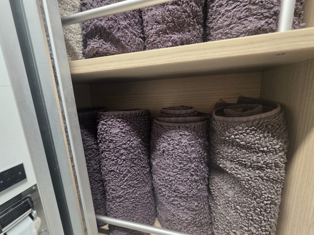 customized-korean-hangeul-towel-souvenir-2026-hotel-delivery A close-up of a premium cotton towel with minimalist Hangeul embroidery on a hotel bed, showcasing the customized Korean Hangeul towel souvenir 2026 delivery service.