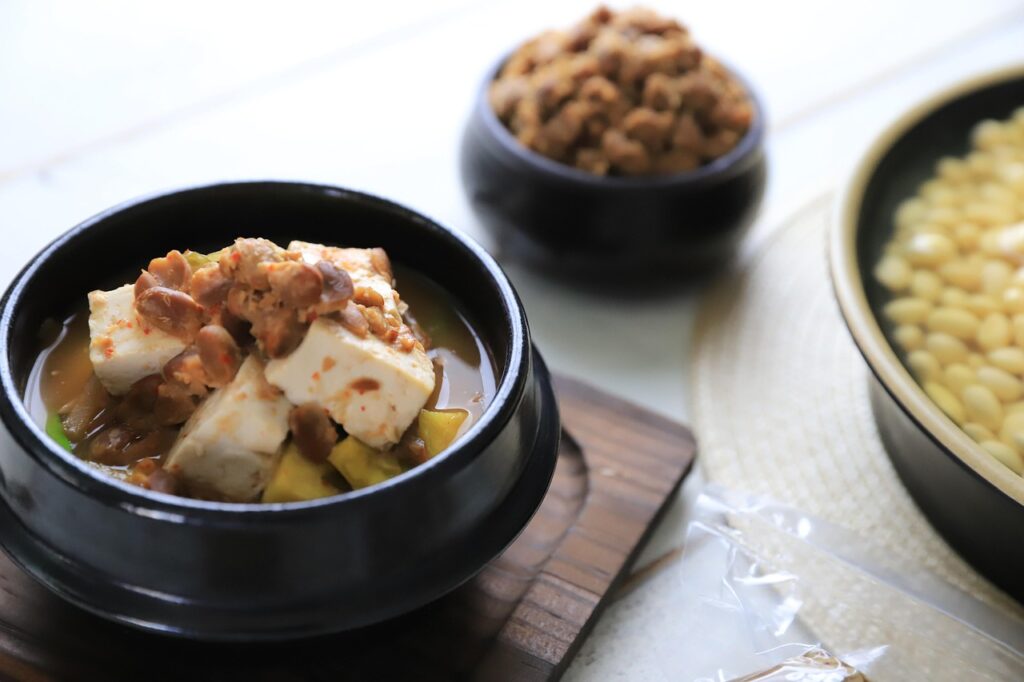 A bubbling pot of Korean doenjang-jjigae stew made with tofu, vegetables, and rich soybean paste broth.