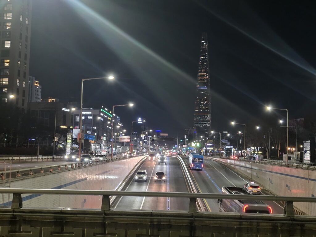driving-in-seoul-night-traffic-rule Night view of a major intersection in Seoul near Lotte World Tower, showing the complex road structure and pedestrian safety zones for expat drivers.