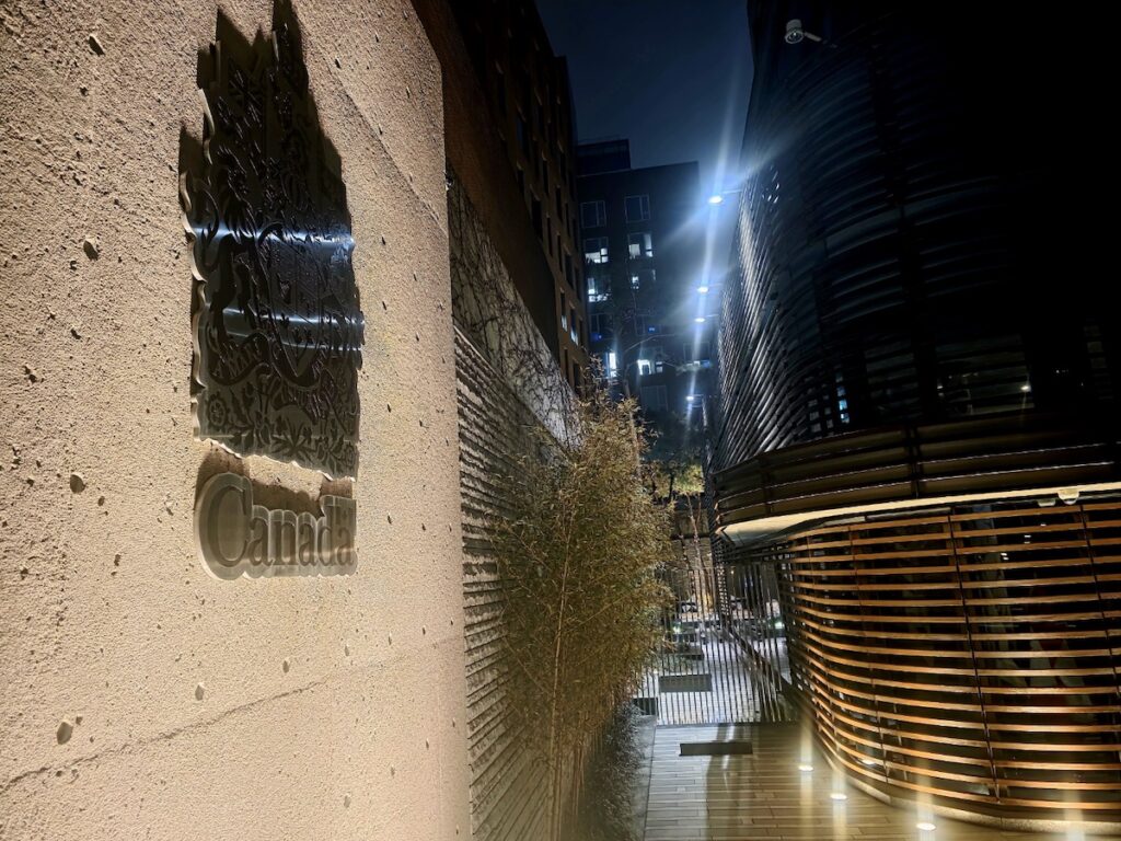 The sophisticated exterior of the Embassy of Canada in Seoul at night, representing the high-level legal stability required to fulfill F-2-99 visa Korea requirements.