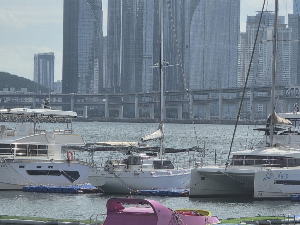 gwangalli-water-sports-yacht-marina-gwangan-bridge Yachts and catamarans docked at the Gwangalli marina with Gwangan Bridge and Marine City behind