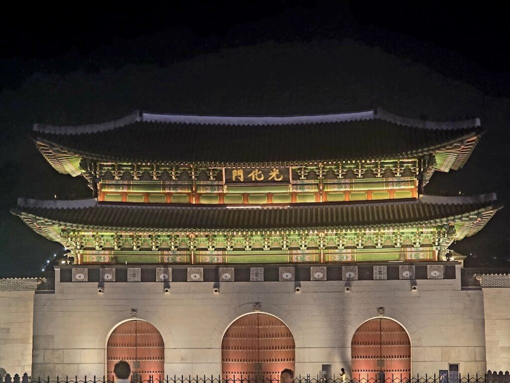 A majestic night view of Gwanghwamun Gate at Gyeongbokgung Palace, symbolizing the foundational legal authority discussed in the South Korea visa guide for professionals.