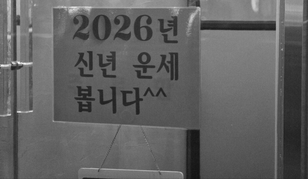 gwanghwamun-saju-2026-new-year-luck A close-up shot of a red sign announcing 2026 New Year fortune-telling for the **Gwanghwamun Saju Tarot 2026** ritual.
