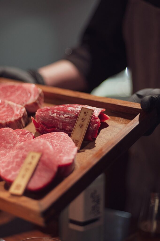 Close-up of high-quality Hanwoo beef cuts showcasing fine marbling, freshness, and rich red color on a butcher’s display.
