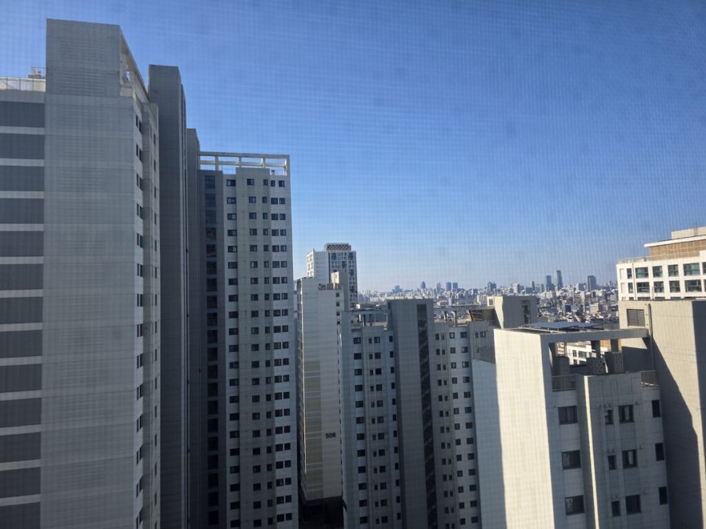 high-rise-housing-view-in-south-korea A view of high-rise residential buildings in South Korea under a clear blue sky, illustrating typical urban living conditions for foreign residents.