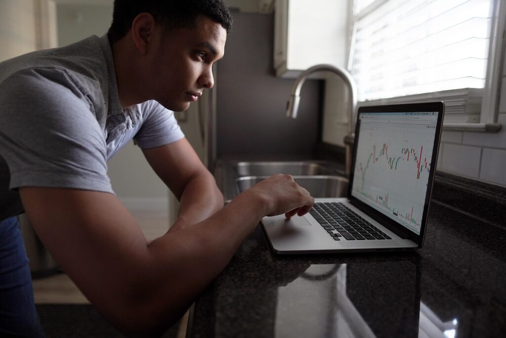 A focused investor analyzing the Korean Stock Market on a laptop, illustrating the strategic process of how to buy Korean stocks as an expat.