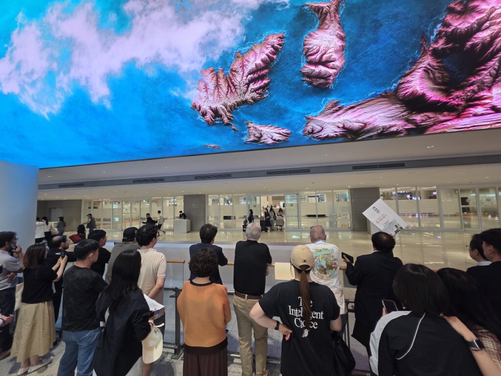 Travelers looking up at the 150-meter media wall above the Incheon Airport arrivals hall