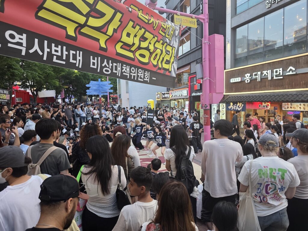is-hongdae-too-crowded-street-performance A large crowd watching a street performance in Hongdae, showing why travelers ask is Hongdae too crowded