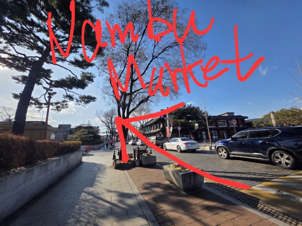 jeonju-hanok-village-experience-path-to-nambu-market A traditional street view showing the walking route toward Nambu Market, an essential part of the Jeonju Hanok Village Experience.