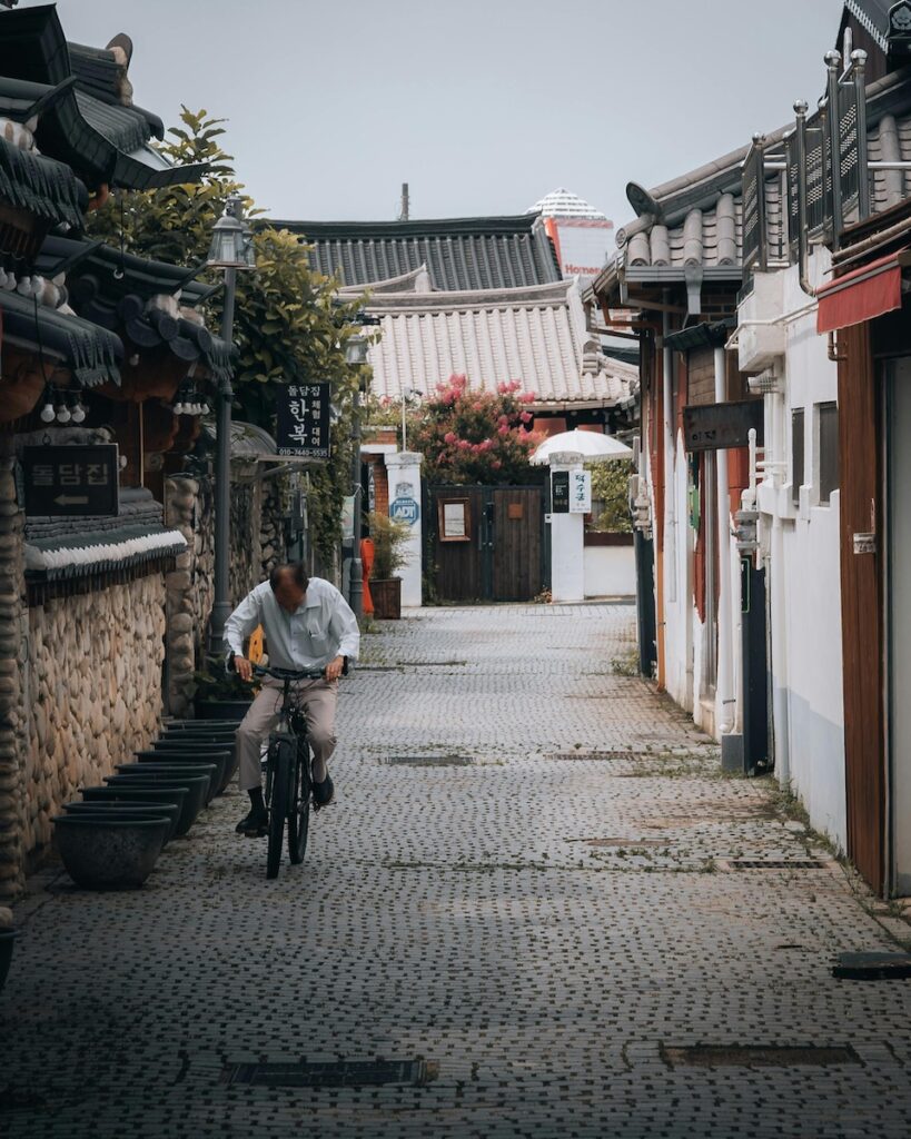 jeonju-hanok-village-traditional-korea “Scenic view of Jeonju Hanok Village with traditional tiled-roof houses and walking visitors”