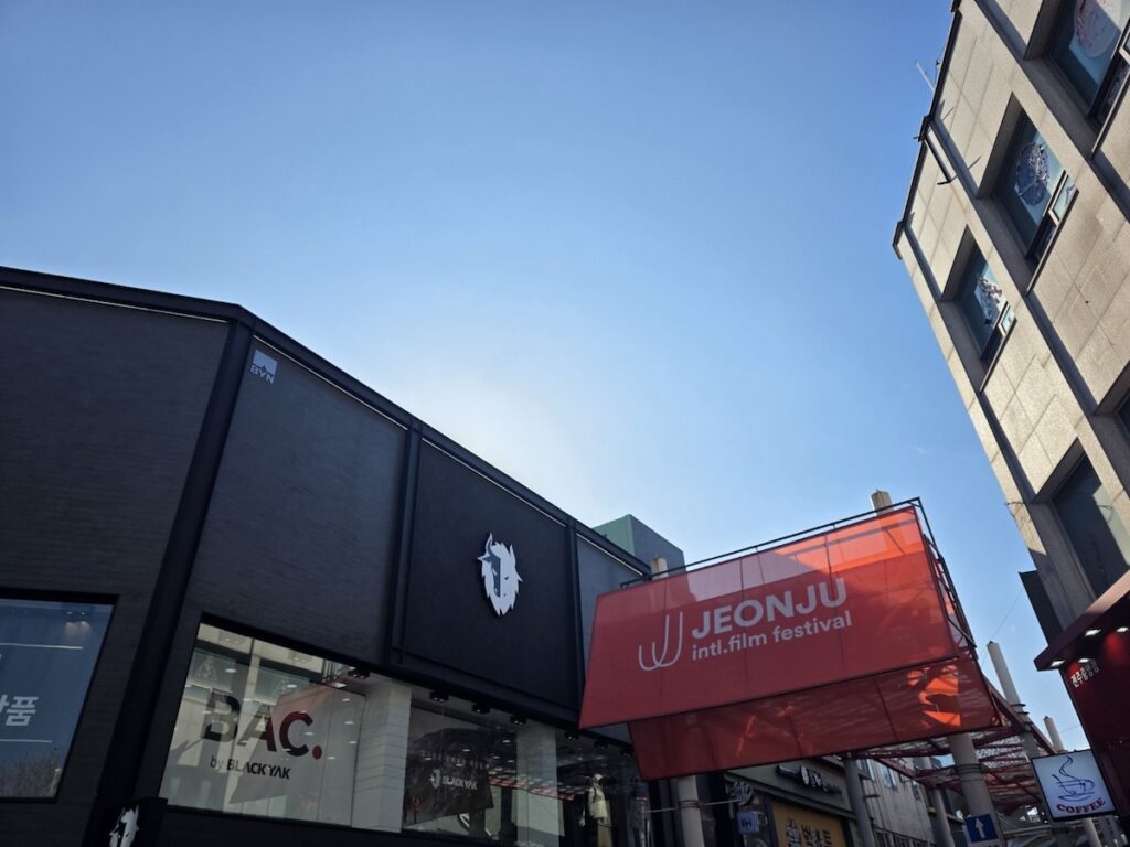 jeonju-international-film-festival-2026-cityscape The modern cityscape of Jeonju featuring a 2026 Film Festival banner, located near the famous **Jeonju Makgeolli Street** area.