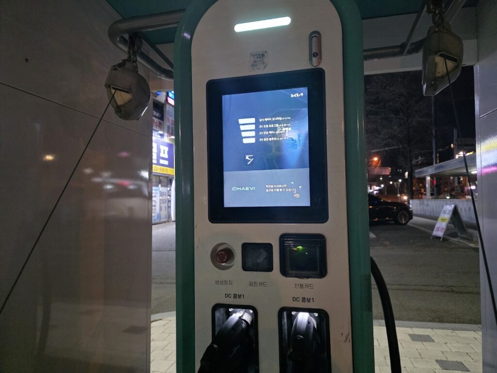 jeonju-night-scenes-ev-charging-station-infrastructure A modern on-street EV charging station, part of the municipal eco-friendly initiatives in Jeonju night scenes.