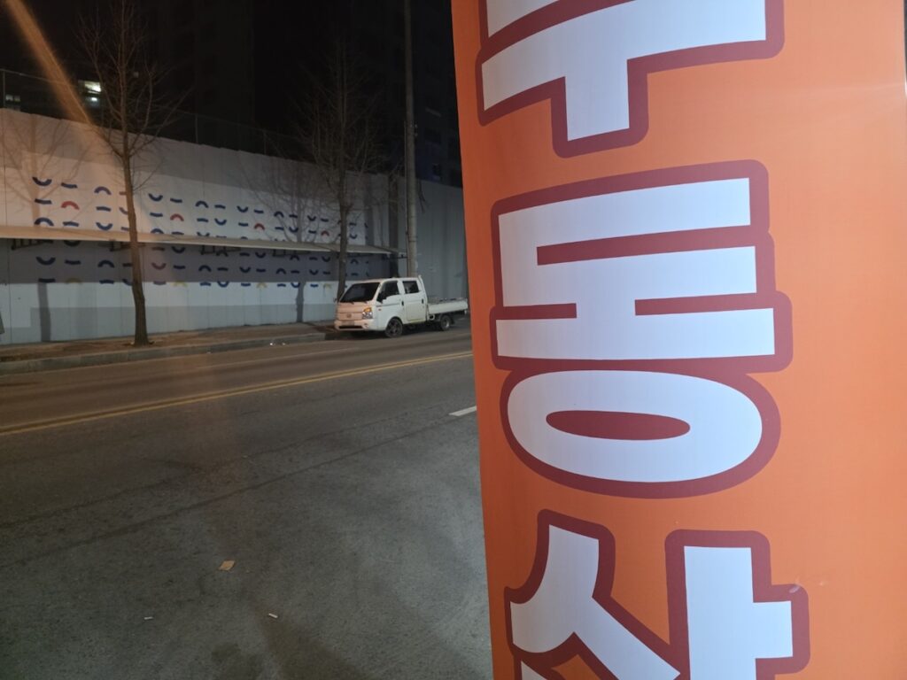 jeonju-night-scenes-neon-air-balloon-advertisement A vibrant red neon air-balloon advertisement illuminating Jeonju night scenes in a commercial district.