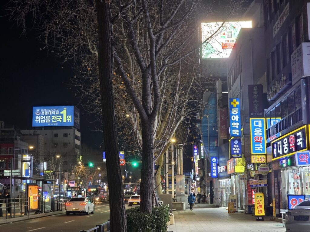 jongno-5-ga-bus-stop-pharmacy-district The bustling bus stop in front of major pharmacies at Jongno 5-ga Pharmacy Street, highlighting the accessibility and urban movement of Seoul's healthcare center.