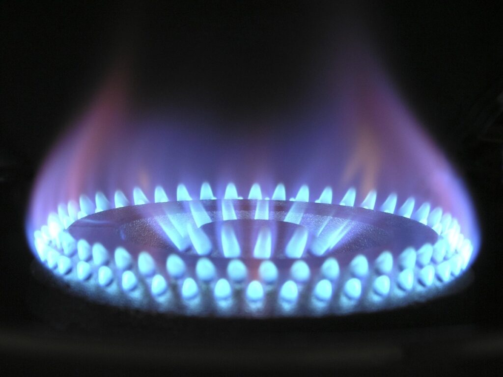 A bright blue gas flame on a stove, representing the city gas and Ondol heating costs that fluctuate in the Korean monthly payment ritual.