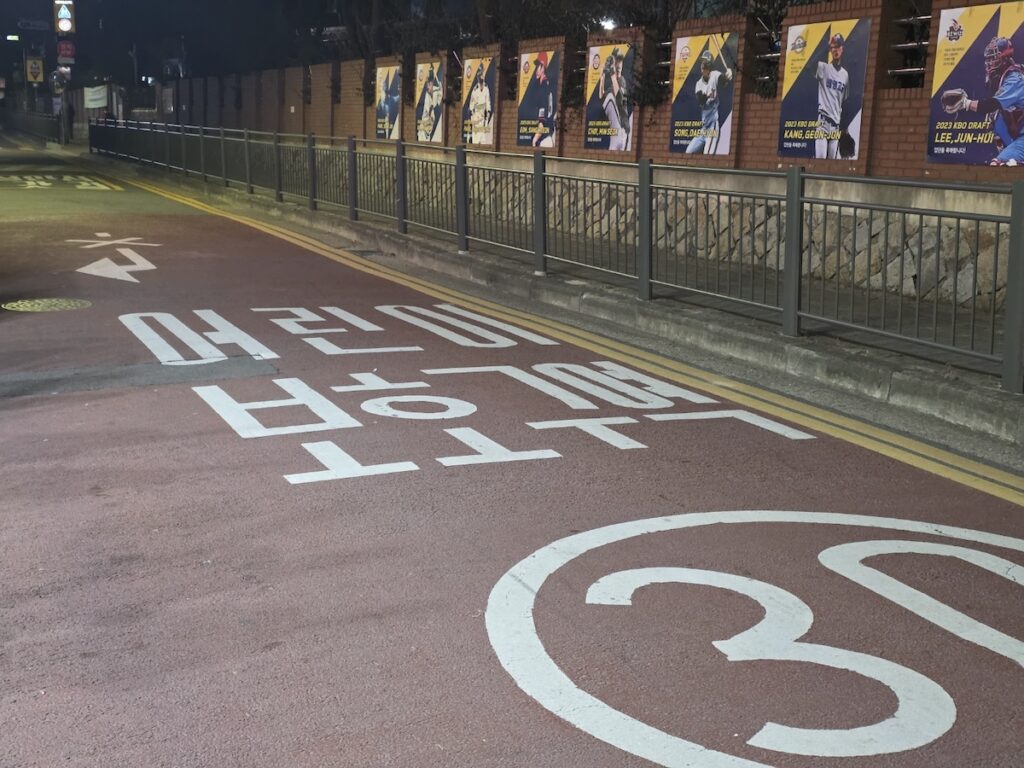 Red-paved school zone street in Seoul with a 30km/h speed limit, illustrating strict Driving Laws in Korea for Foreigners and the need for legal insurance.