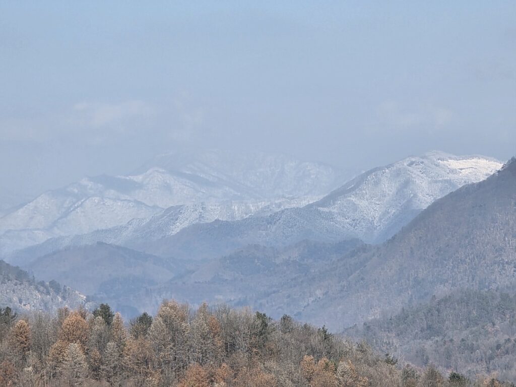 korea-hiking-ritual-2026-owners-cc-view A wide horizon of snow-capped mountains beyond the Owners CC golf course, captured during the physical resilience ritual of Hiking in Korea 2026.