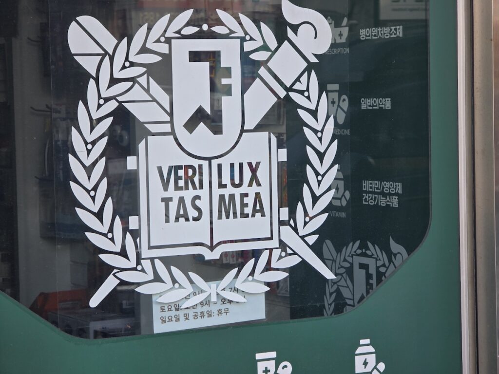 korea-pharmacy-guide-2026-veritas-lux-mea The Seoul National University medical emblem on a pharmacy door, showcasing the professionalism in the Korea Pharmacy Guide 2026.