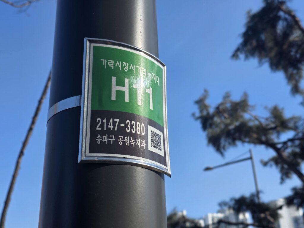 korea-state-grid-number-emergency-location-sign A green State Grid Number sign (κ΅κ°μ§μ λ²νΈ) used for rescue in Korean mountains and parks, providing exact coordinates when you report to 112 and 119.