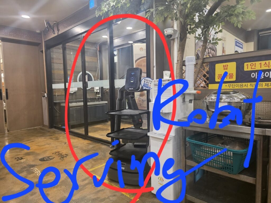 Korea Travel: Gangnam Station Robot Server - A high-tech serving robot with LiDAR sensors in action.