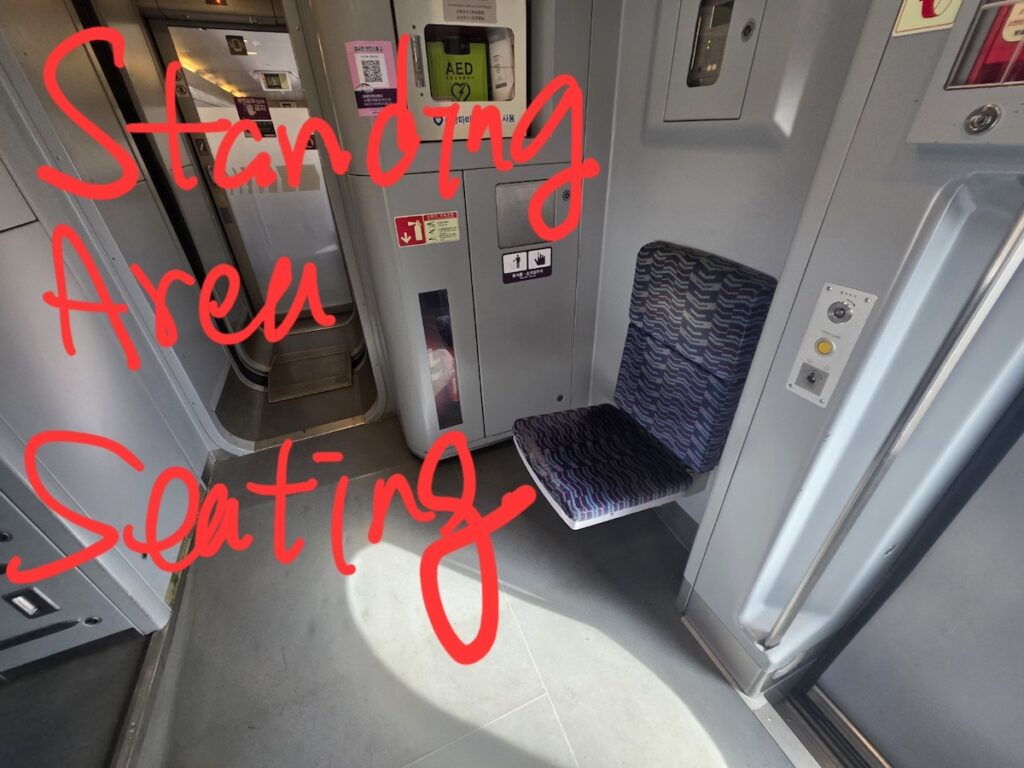 korea-travel-ktx-standing-ticket-ritual-fold-down Korea Travel: KTX Standing Ticket Ritual - A close-up of the strategic fold-down seat.