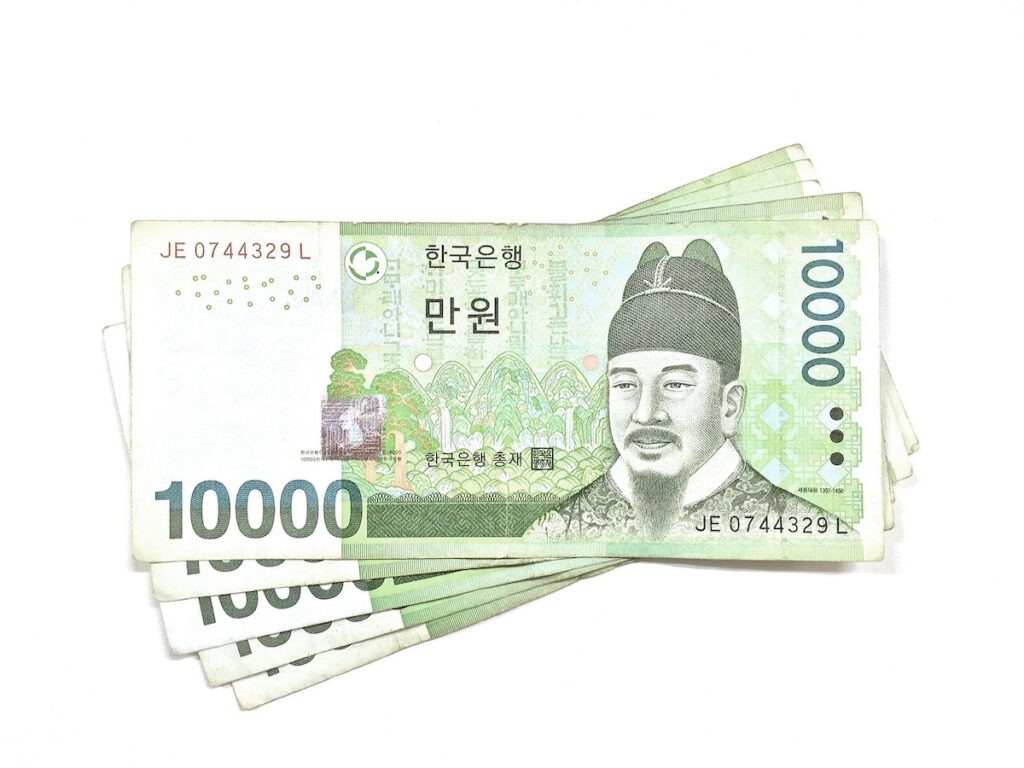 korean-bank-currency-ten-thousand-won A cinematic close-up of 10,000 Won notes, symbolizing the tangible liquid assets managed by a premier Korean Bank.