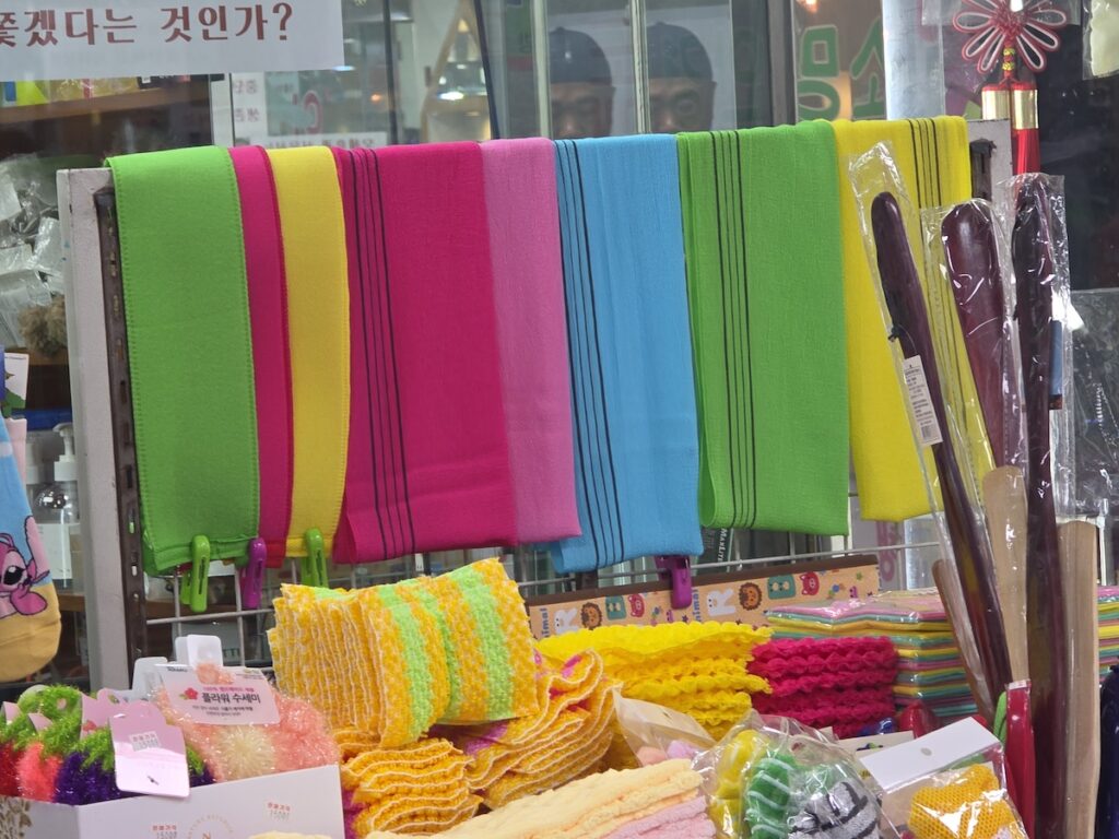 Colorful Korean Italy towels displayed at a market shop for Korean body scrub at home, showing different scrub towel colors and bath items