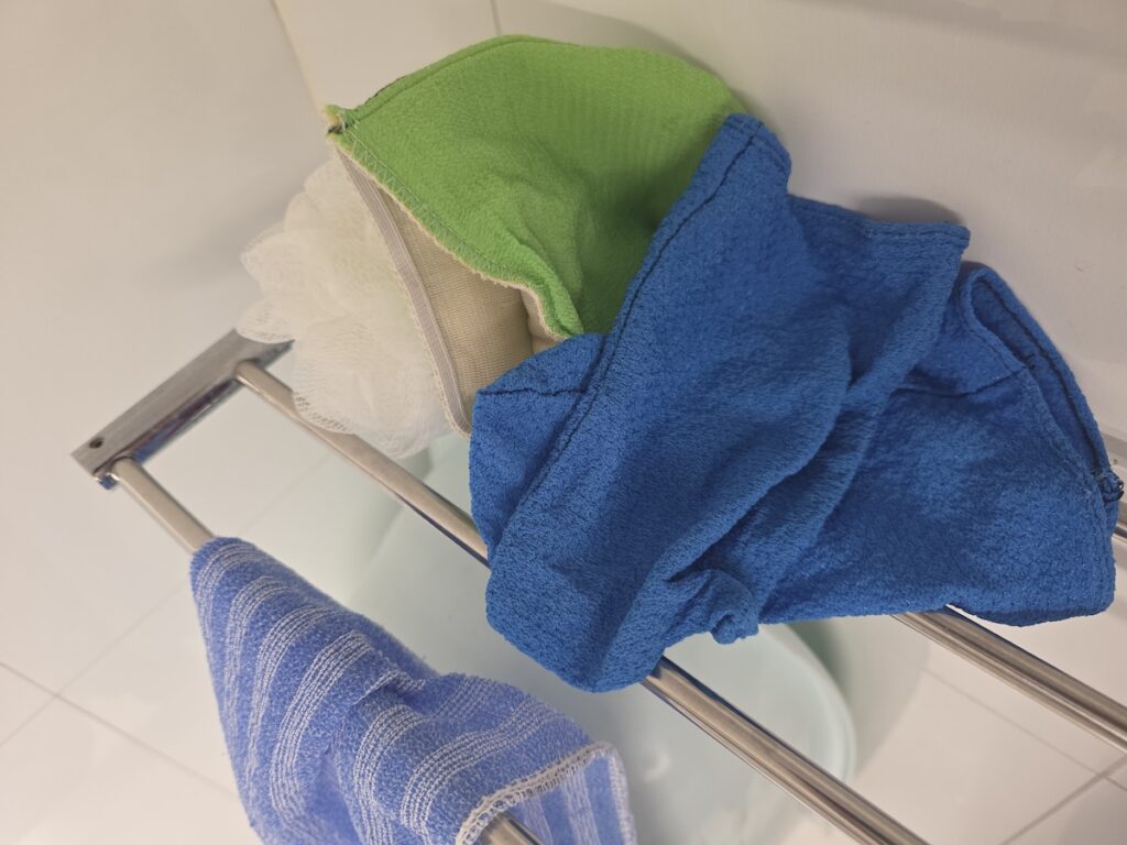 korean-body-scrub-at-home-towel-and-aloe-routine Korean Italy towels drying in a bathroom with a regular towel, showing a simple Korean body scrub at home routine after showering