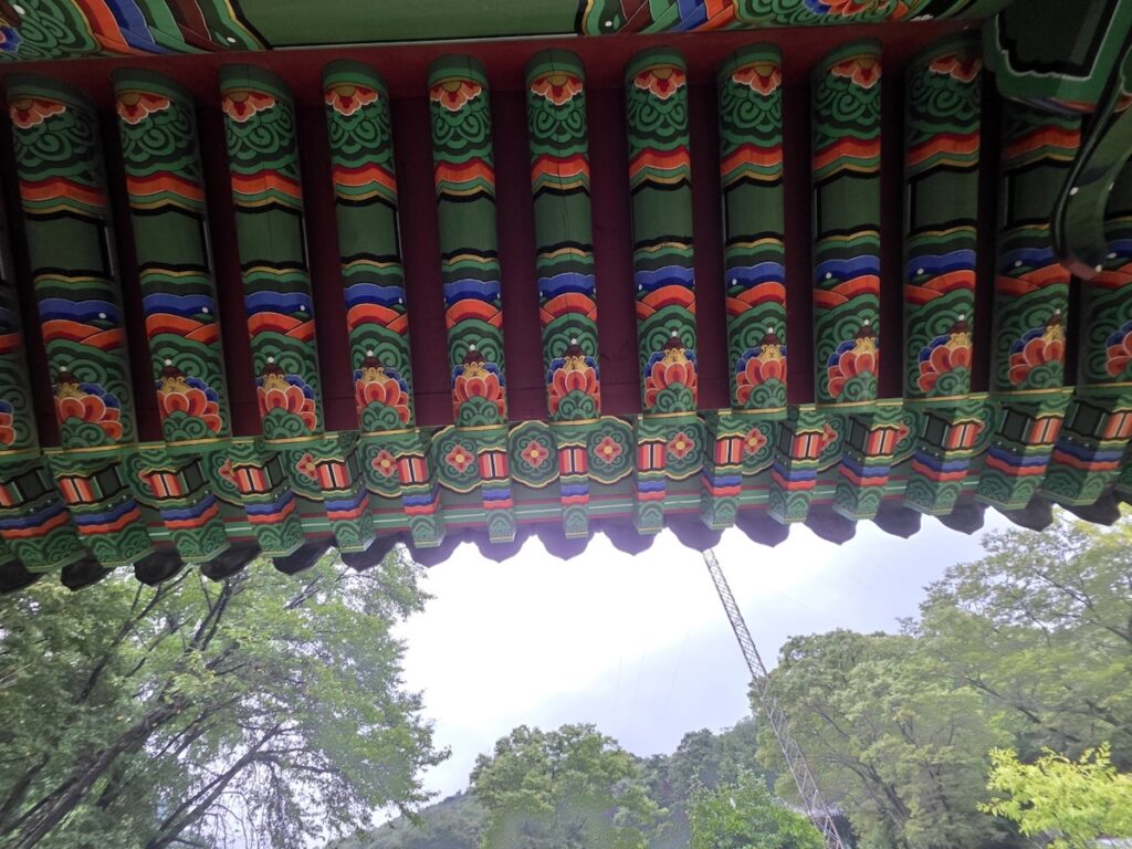 korean-buddhist-temple-architecture Traditional Korean Buddhist temple architecture with curved tiled roofs, wooden structures, and serene courtyard — representing temple stay culture in Korea.