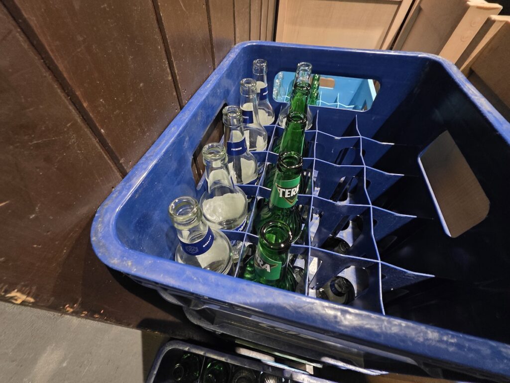 Empty soju and beer bottles in a crate showing Korean drinking culture after a shared meal