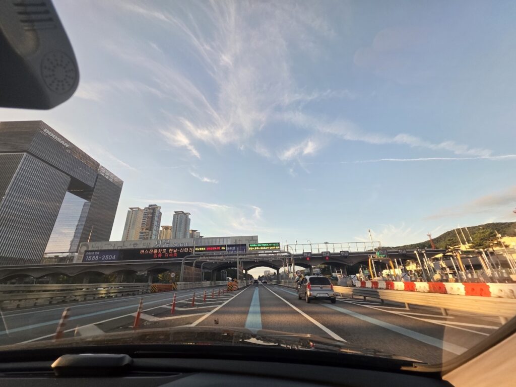 “Korean expressway rest area with food stalls and travelers enjoying local snacks”