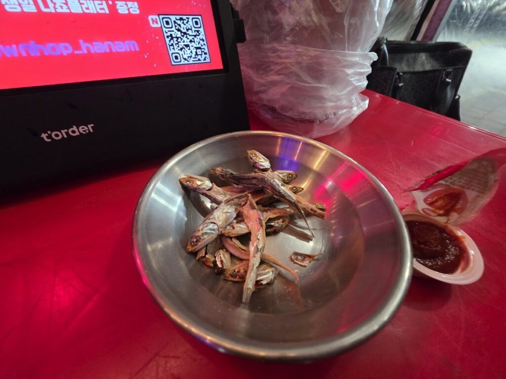 korean-free-snacks-anchovy A bowl of free dried anchovies and gochujang dip served at a Korean pub.