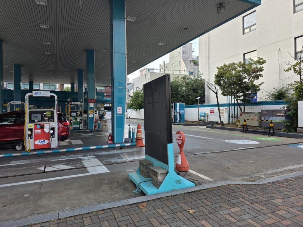 “Exterior view of a Korean gas station with fuel pumps and brand sign visible”