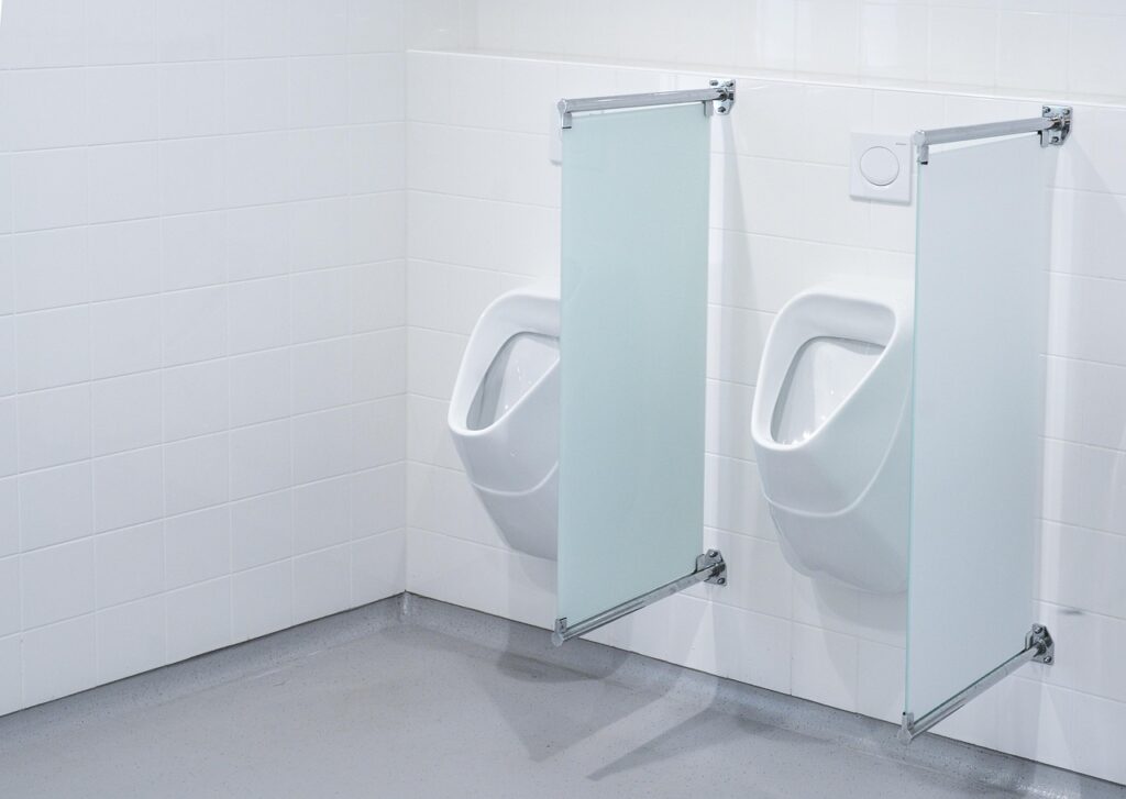 "A white male urinal in a Korean public restroom showing typical design and cleanliness standards, often used in discussions about toilet etiquette for men."