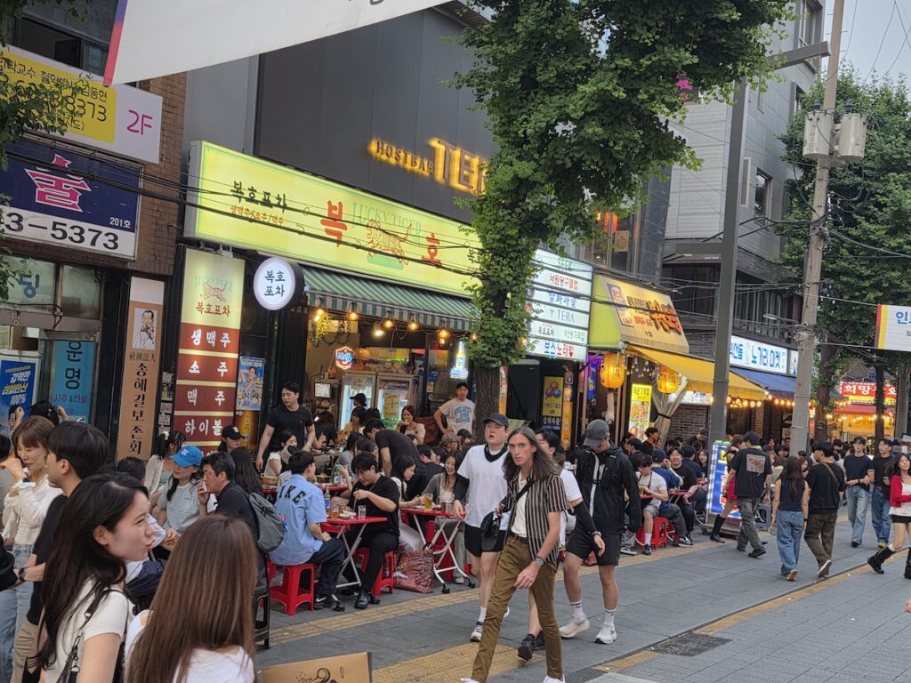 korean-outdoor-drinking-culture-plastic-stools-tables Red and blue plastic stools and folding tables on a Seoul sidewalk, the basic furniture of Korean outdoor drinking culture