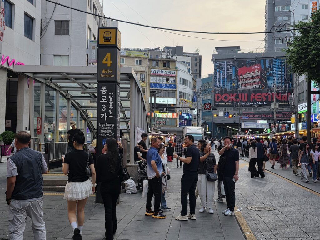 korean-outdoor-drinking-culture-pocha-street-tables Busy Jongno pocha street with red outdoor tables, a scene of Korean outdoor drinking culture
