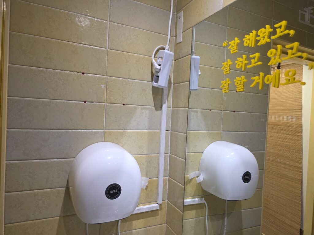 korean-restaurant-bathrooms-hand-dryer Modern white automatic hand dryers installed in Korean restaurant bathrooms to ensure touchless hygiene.