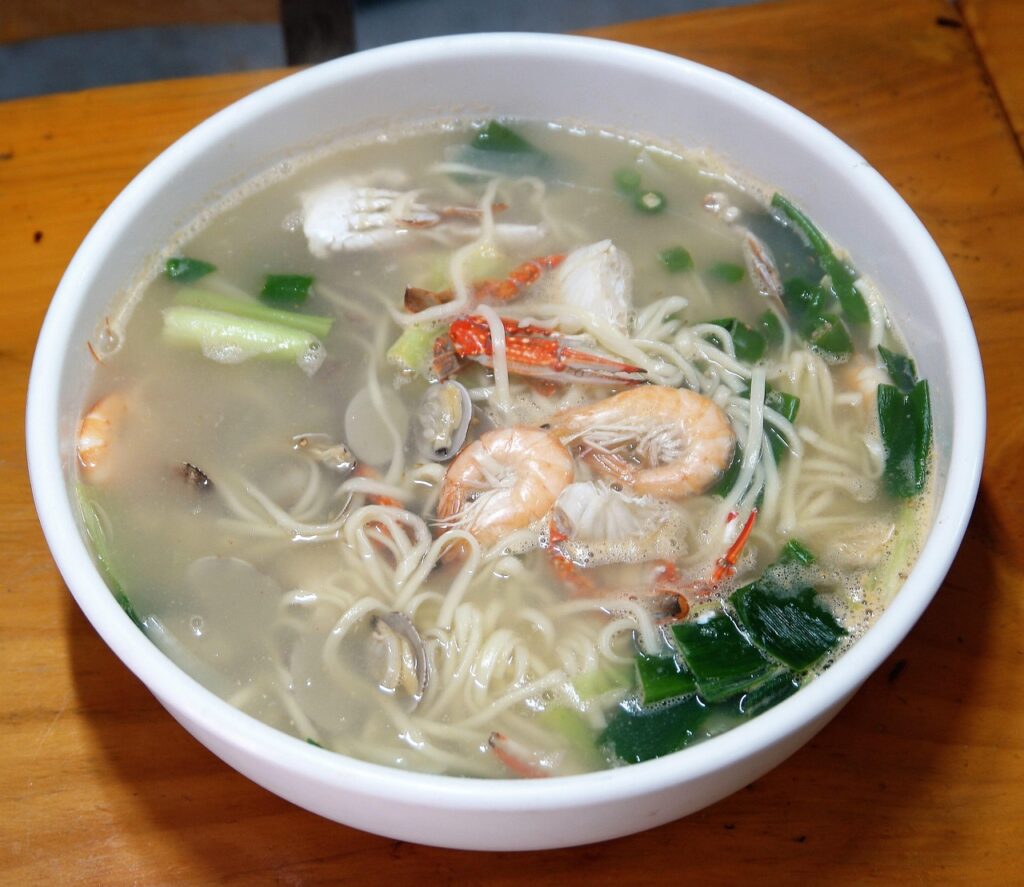 korean-seafood-kalguksu-noodle-soup-2025 “A steaming bowl of Korean seafood kalguksu noodle soup with clams, squid, and shrimp, representing comforting ocean flavors in Korean cuisine.”