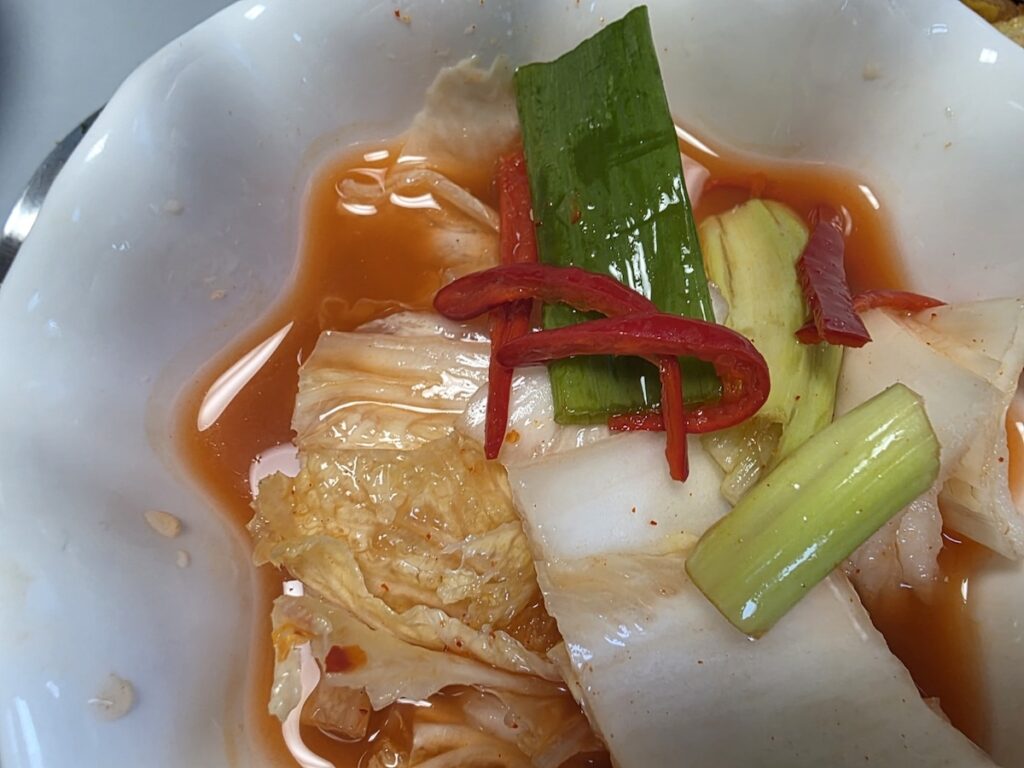 7 Essential Tips for Vegetarians in Korea featuring traditional mul-kimchi served in a clear, refreshing broth.