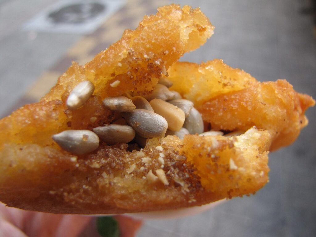 korean-winter-street-food-hotteok-pancake A freshly cooked Korean sweet pancake called hotteok, filled with brown sugar syrup and served hot at a street food stall in winter.